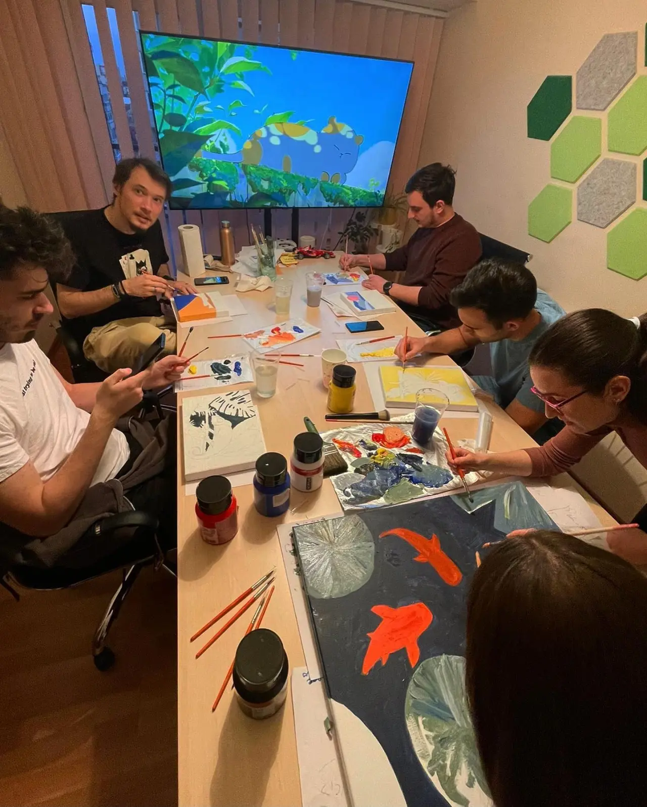The team gathered around the table for a paint night